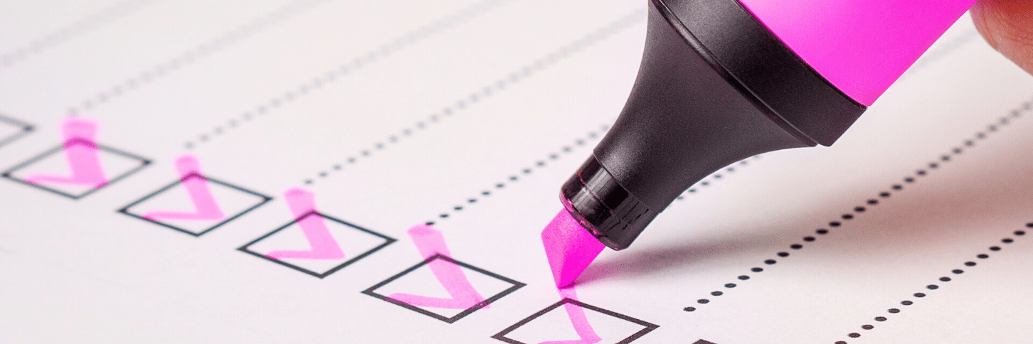 Person checking a box on a checklist with a pink marker